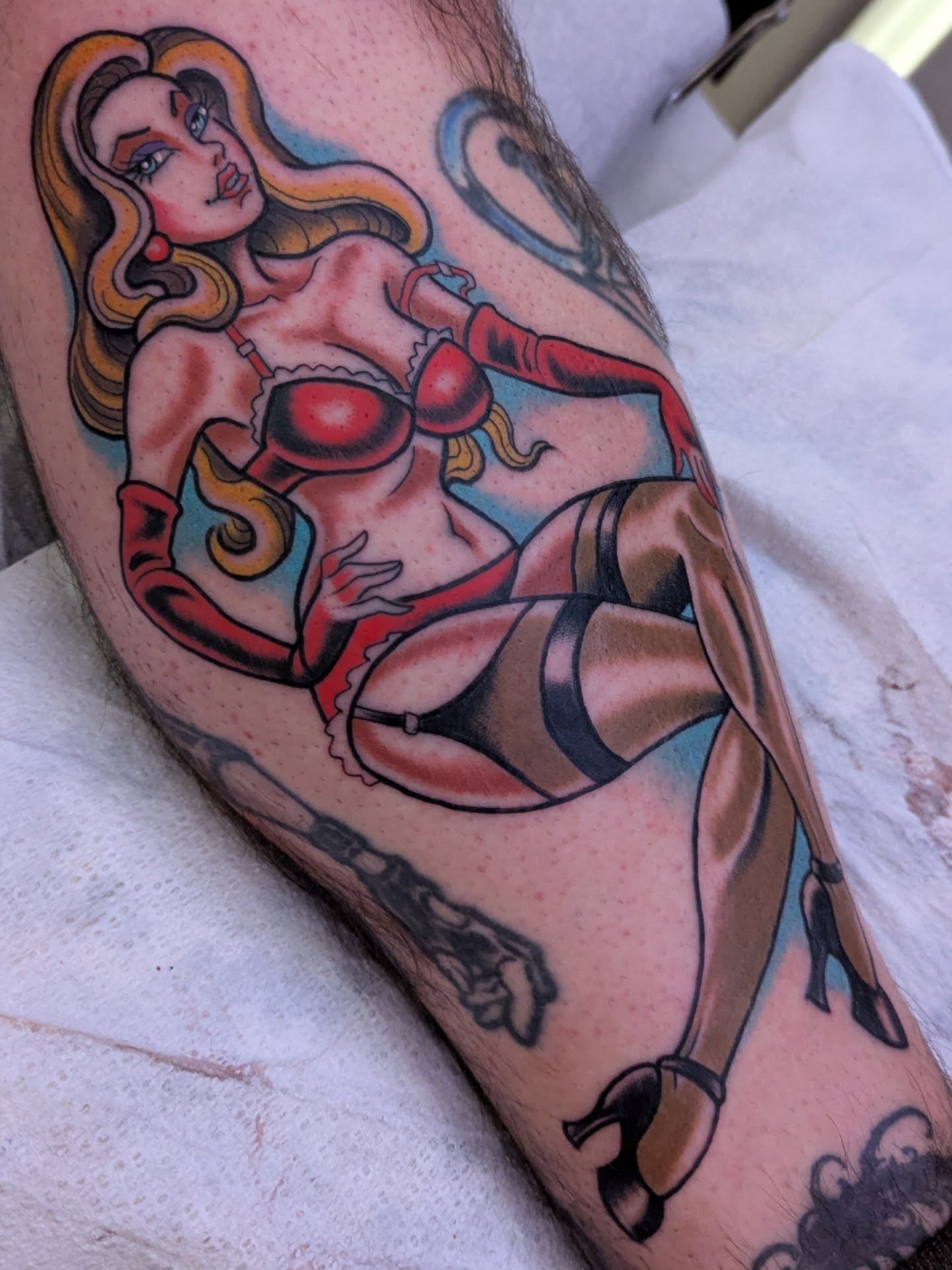 Pin-up girl American traditional tattoo on the thigh by Ryan Slegel