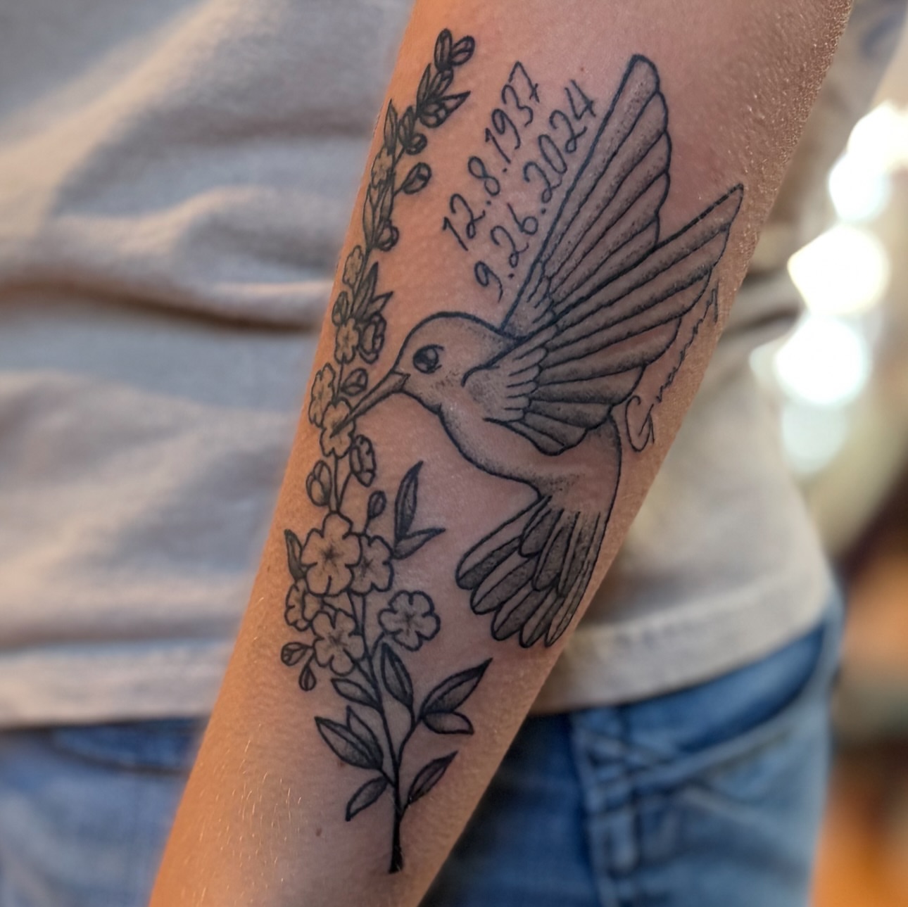 Hummingbird and flowers black and grey tattoo on the forearm by Maddy ⁂, Murfreesboro, Tennessee