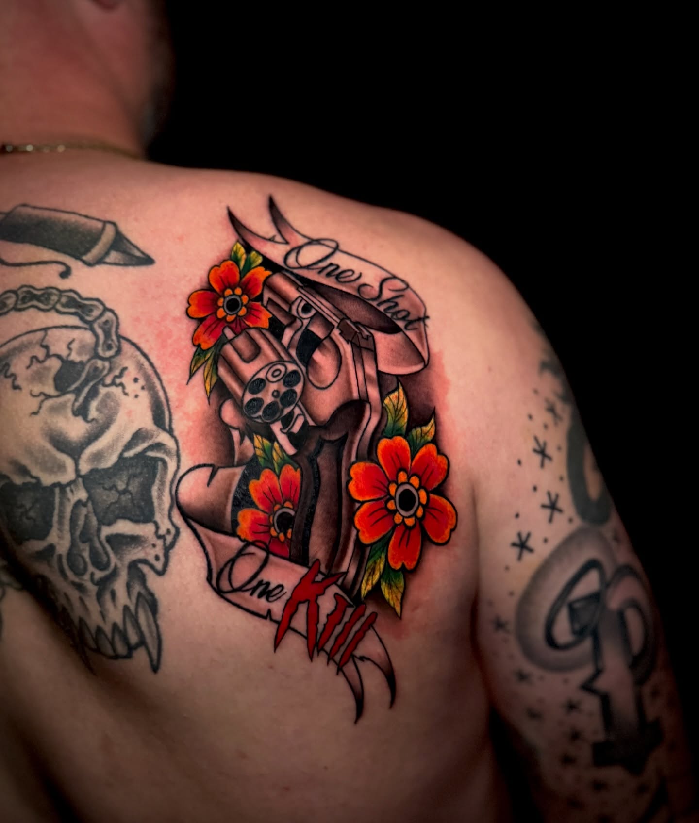 Gun and flowers American traditional tattoo on the shoulder by Ryland - Tattoo Artist
