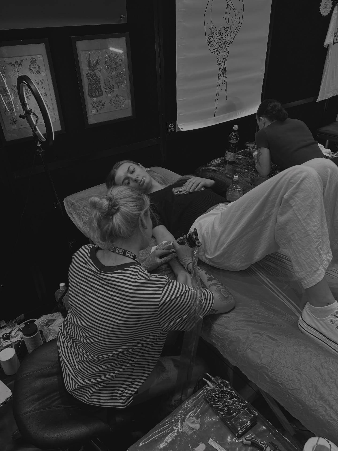 Tattoo artist working black and grey tattoo on the leg by Amara Lyons, Matakana, New Zealand