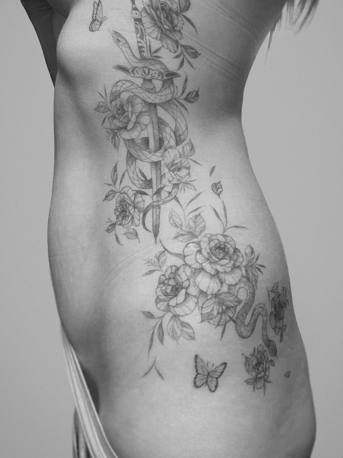 Snake and roses black and grey tattoo on the torso by Yeonji