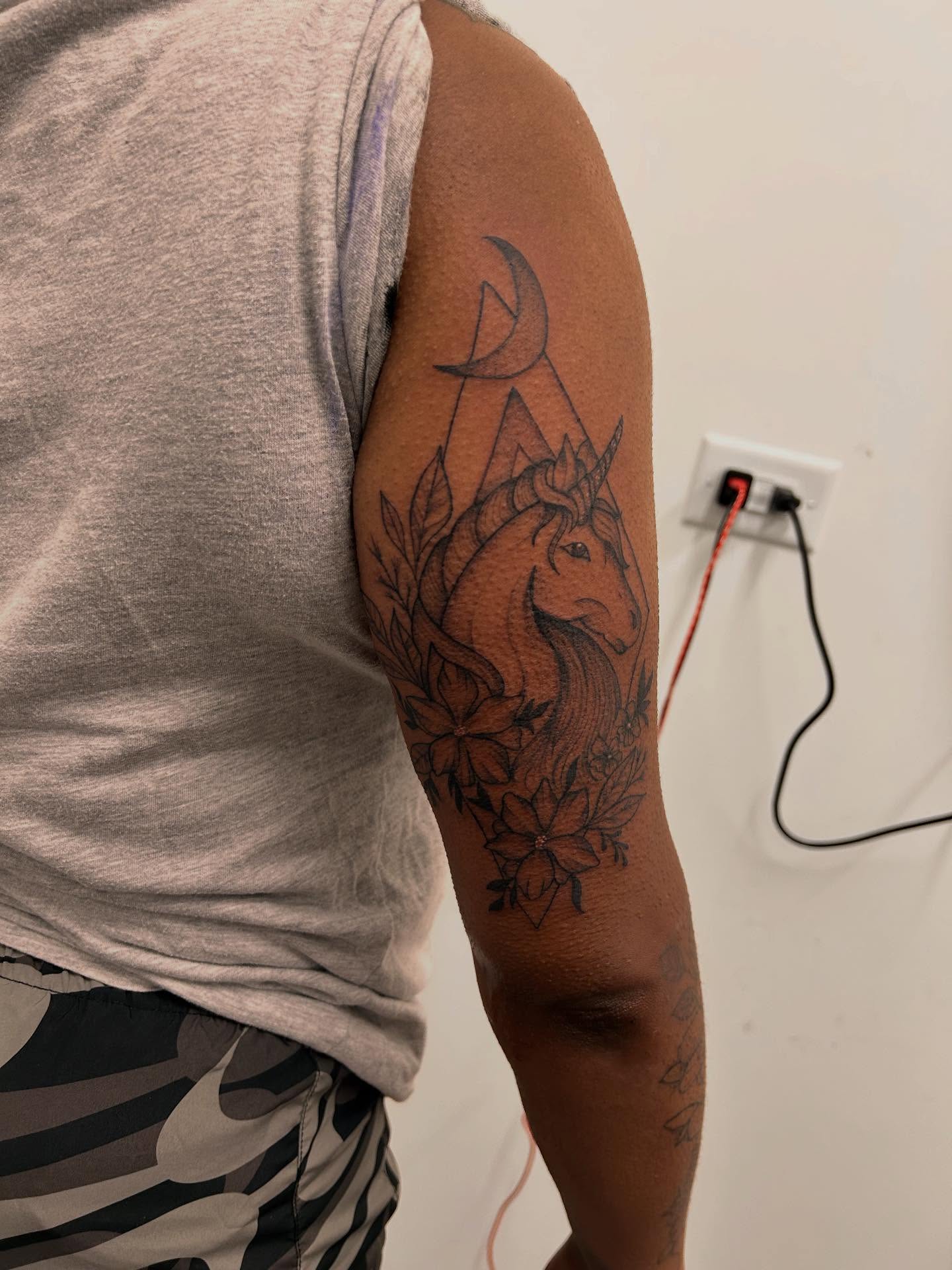 Unicorn and crescent moon black and grey tattoo on the upper arm by Stephania ATLANTA TATTOO ARTIST🎨