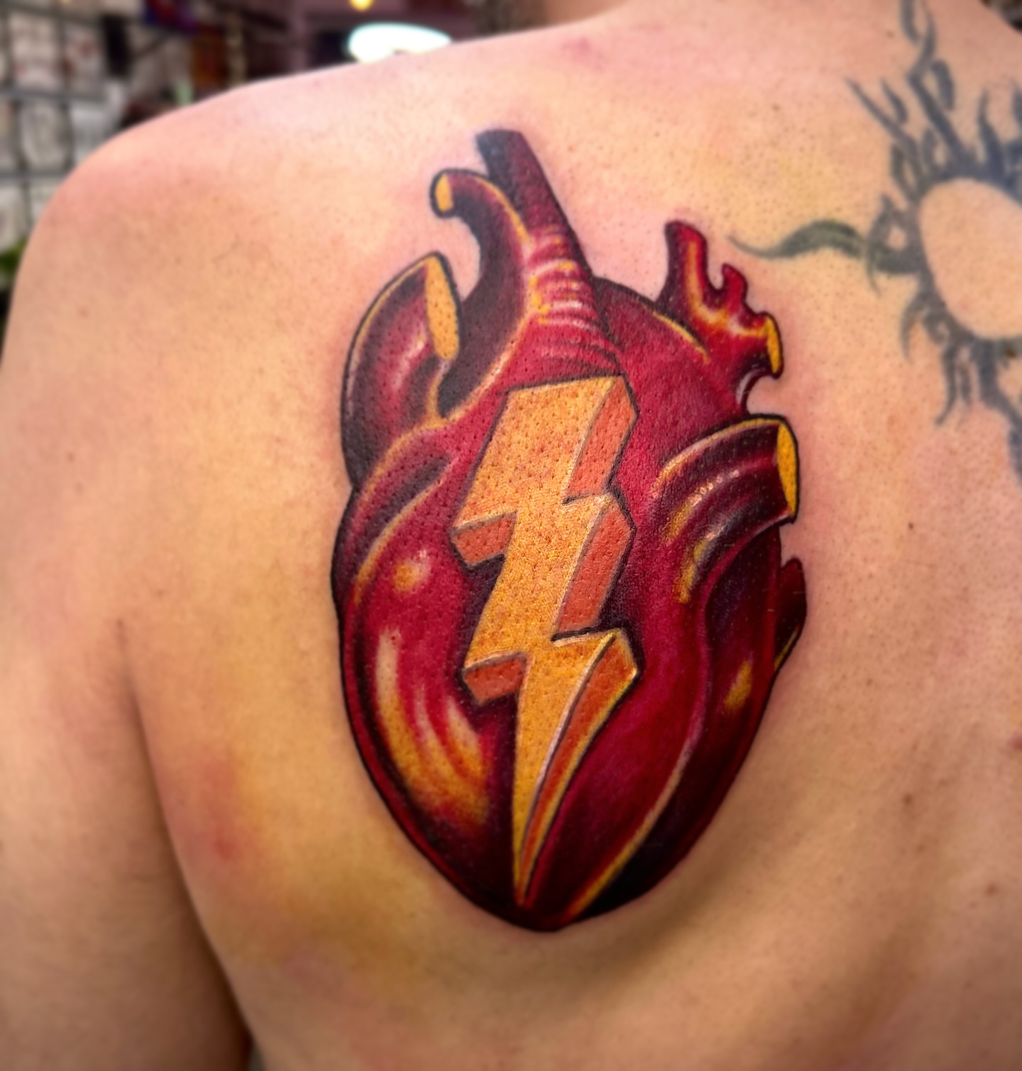 Heart with lightning bolt new school tattoo on the shoulder by Ryan Willard, Denver, Colorado