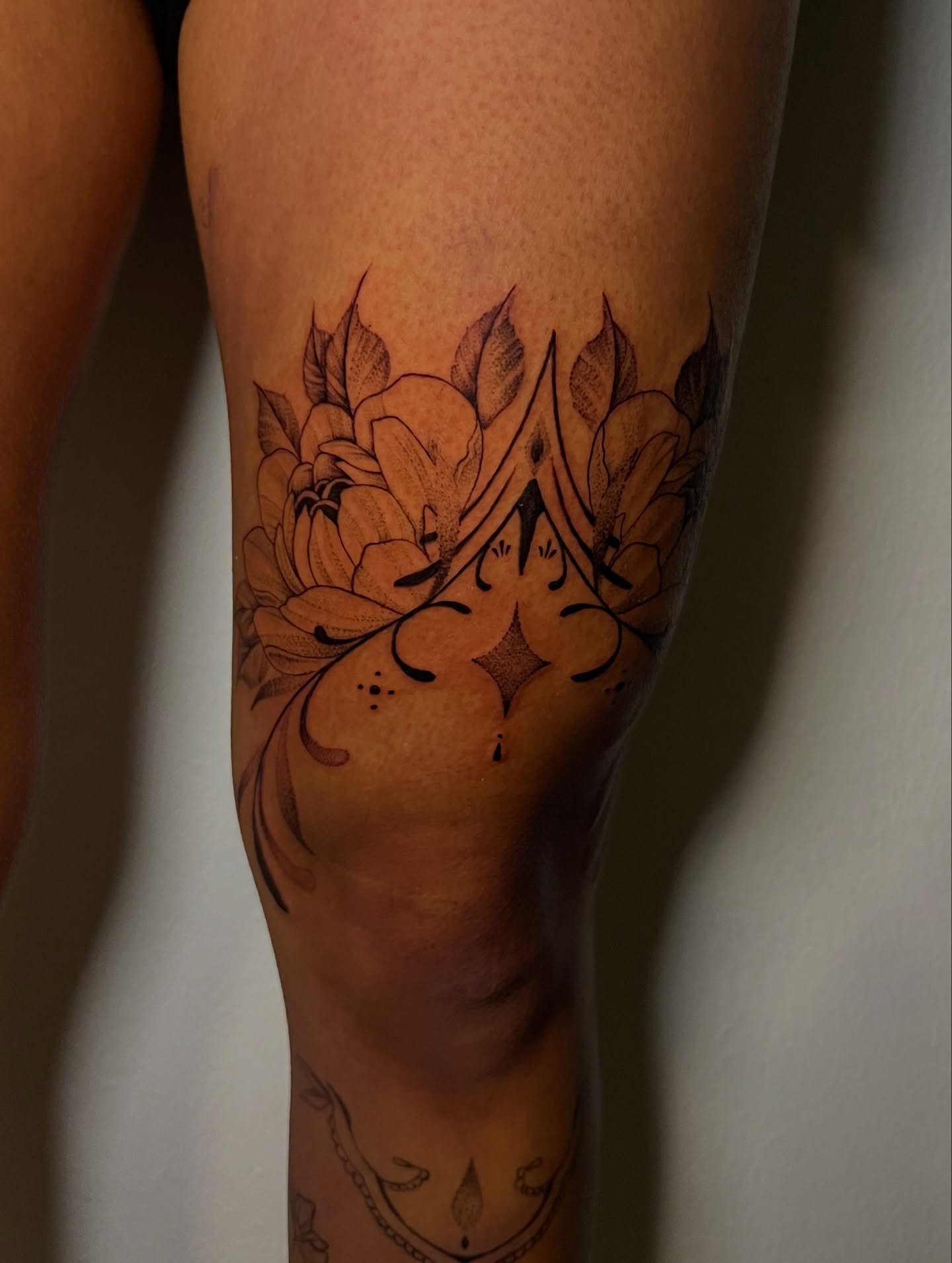Floral arrangement black and grey tattoo on the calf by Jacob Sass