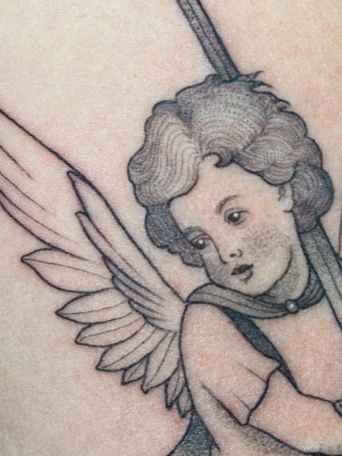 Angel black and grey tattoo on the upper arm by Marissa Whitaker