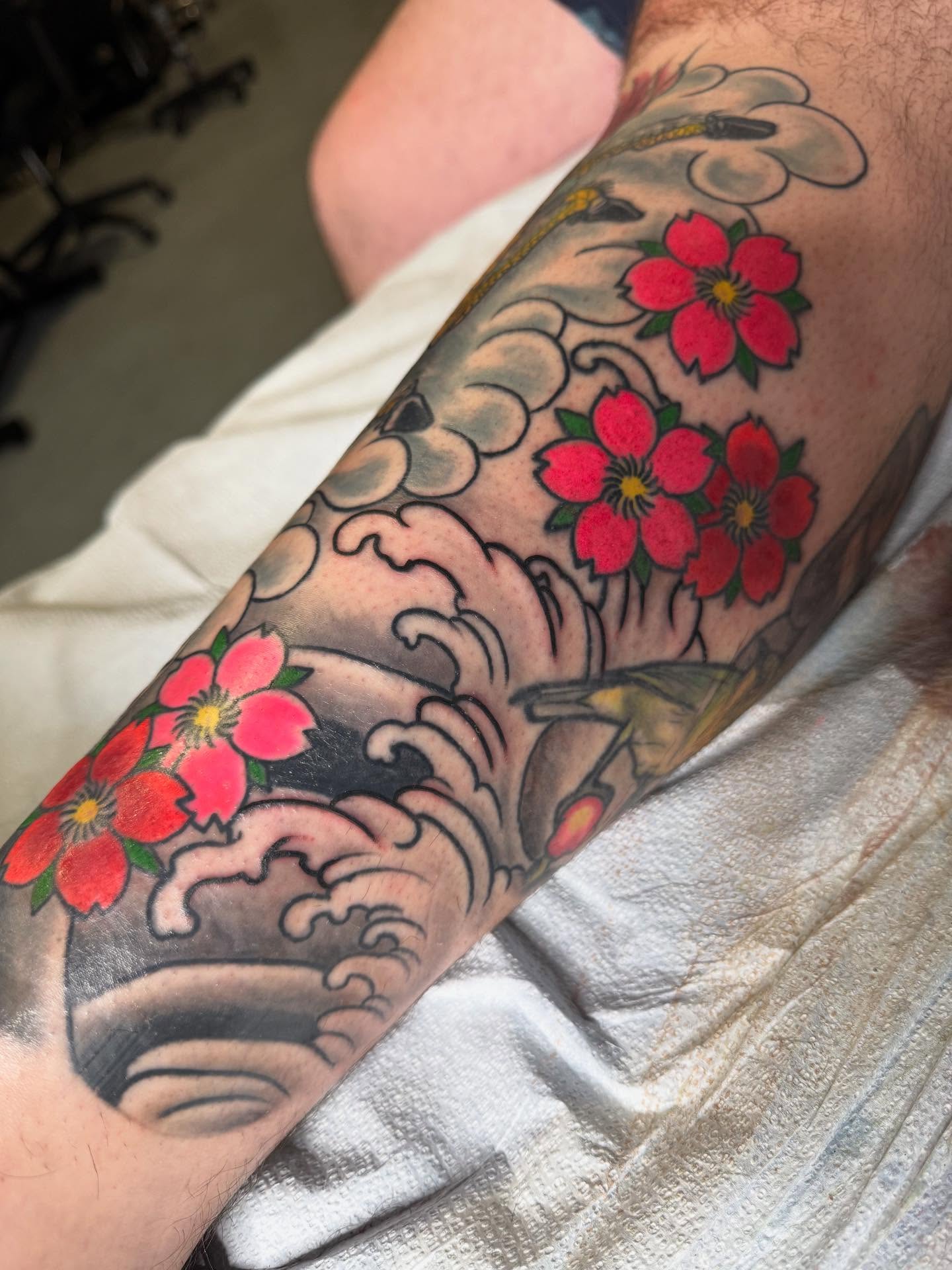 Cherry blossoms and waves japanese irezumi tattoo on the forearm by Randall Croley El