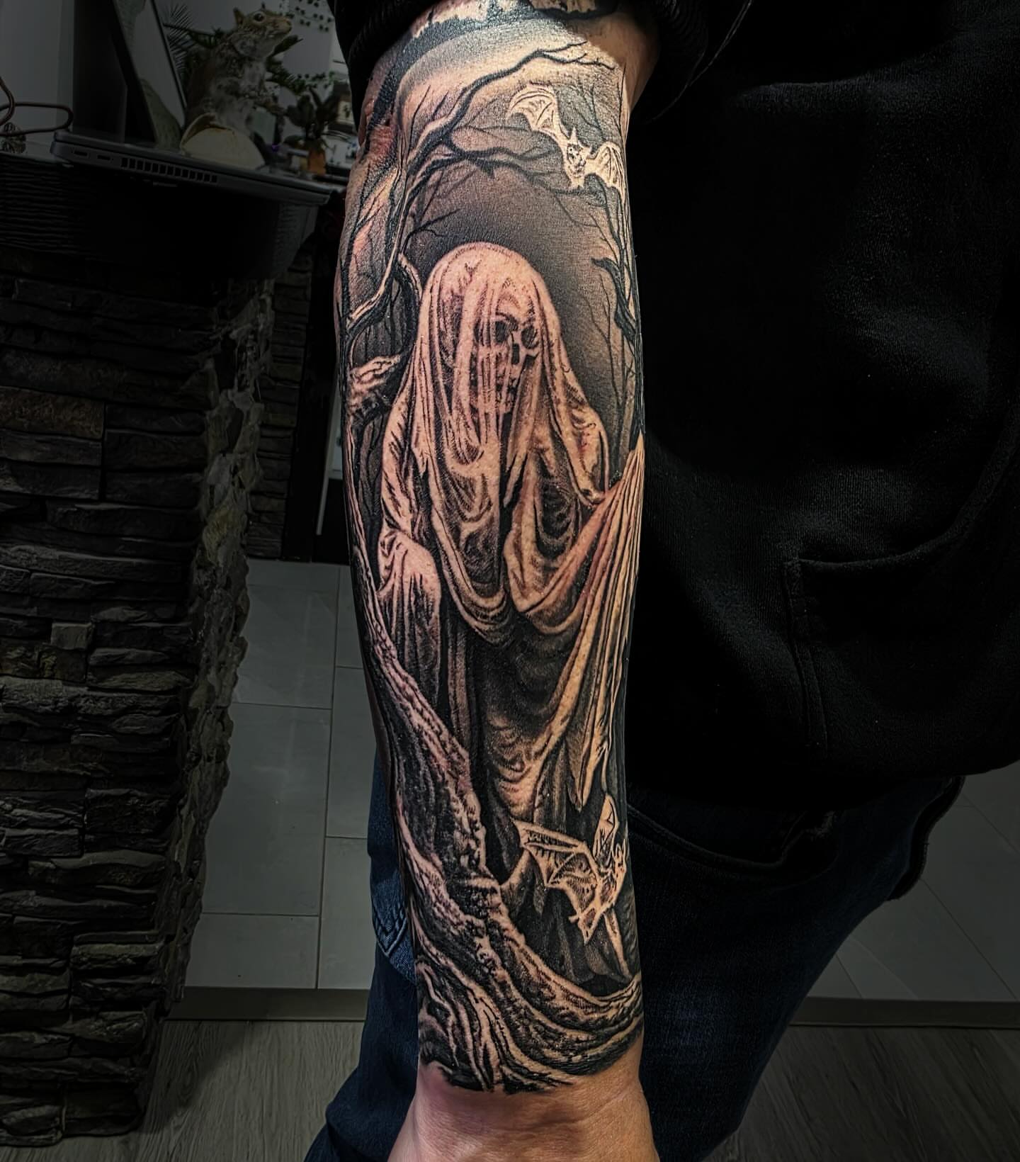 Ghostly figure dark realism tattoo on the forearm by Julia Oravets