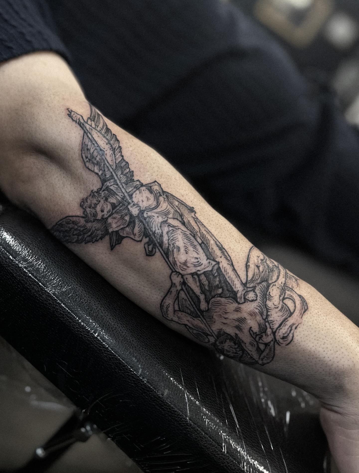 Angel with sword black and grey tattoo on the forearm by Elvira Savchuk