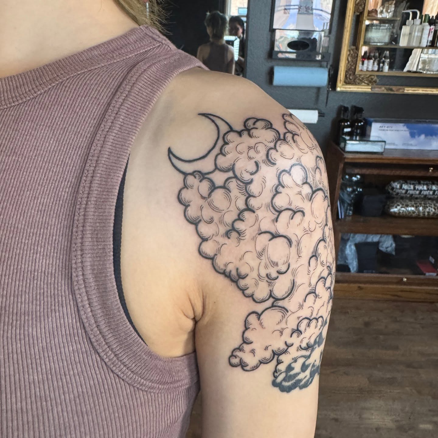 Clouds and crescent moon black and grey tattoo on the shoulder by Lora Bird