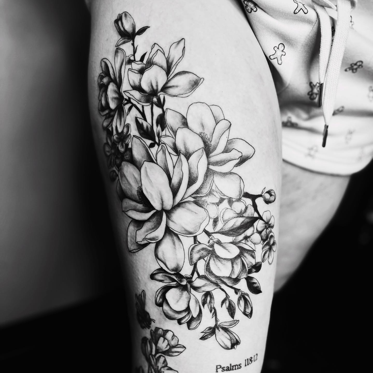 Magnolia flowers realism tattoo on the thigh by Sydney Rose