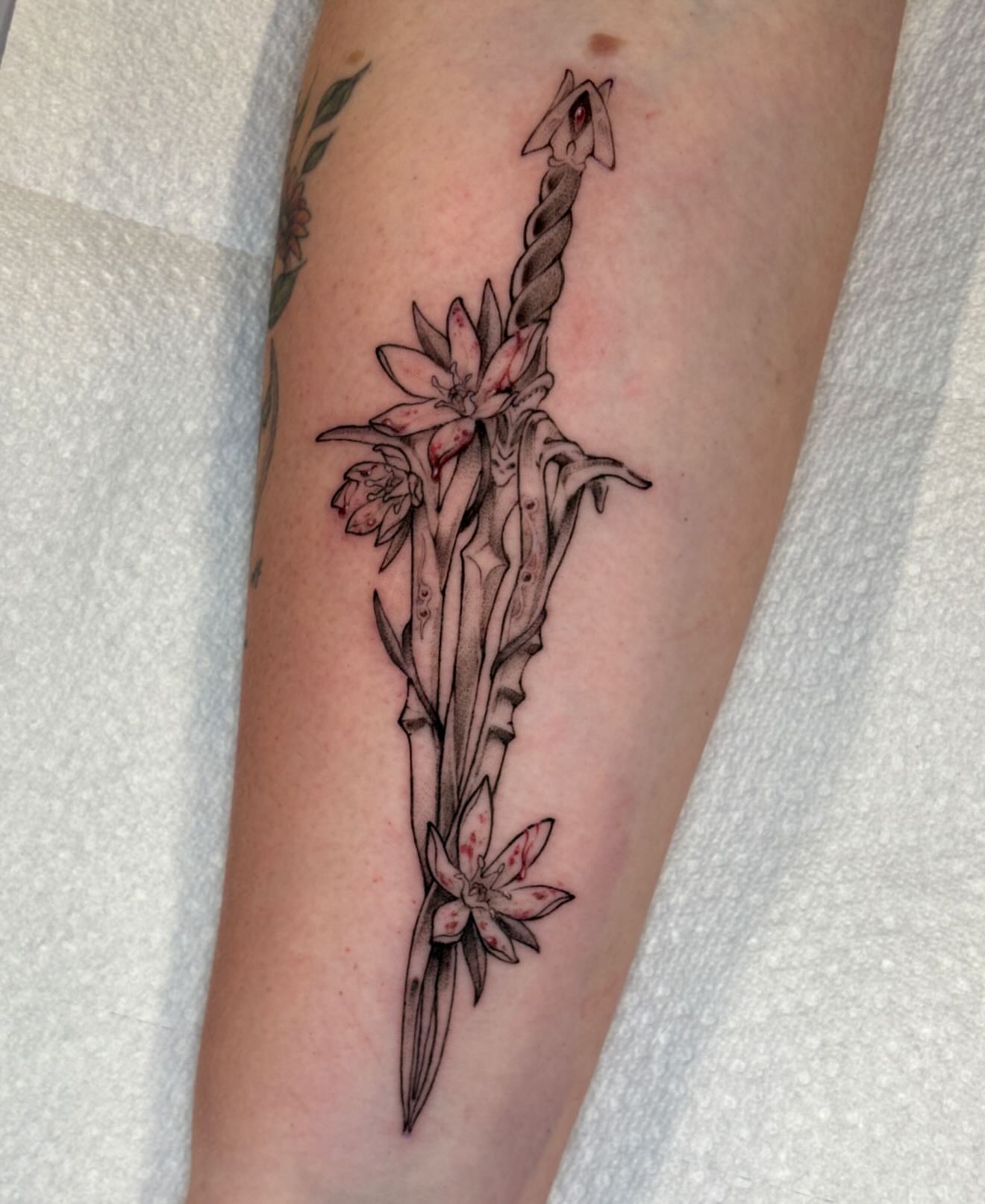 Sword and flowers black and grey tattoo on the forearm by jo, Wichita, Kansas