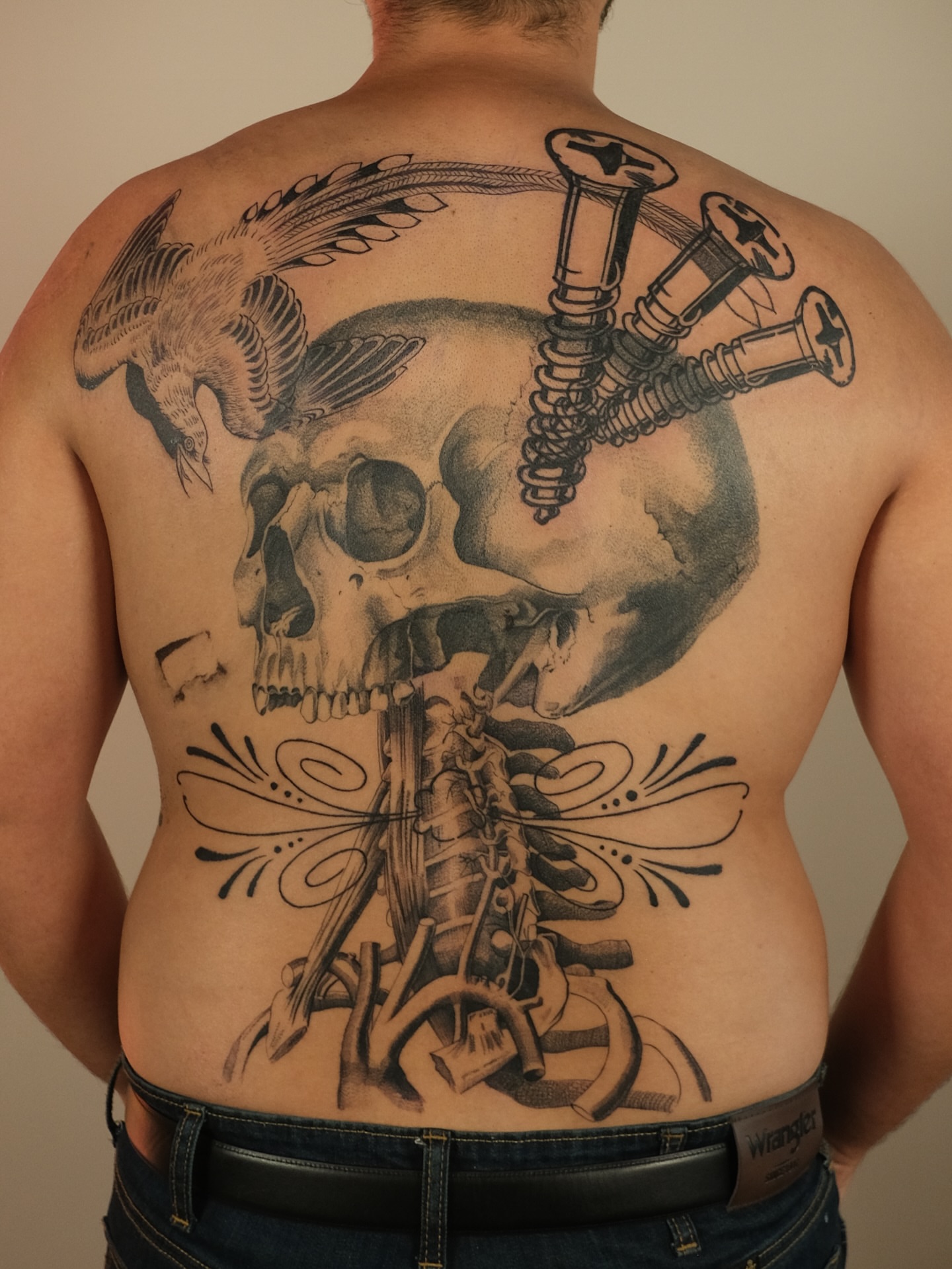 Skull and screws realism tattoo on the back by Zanereti