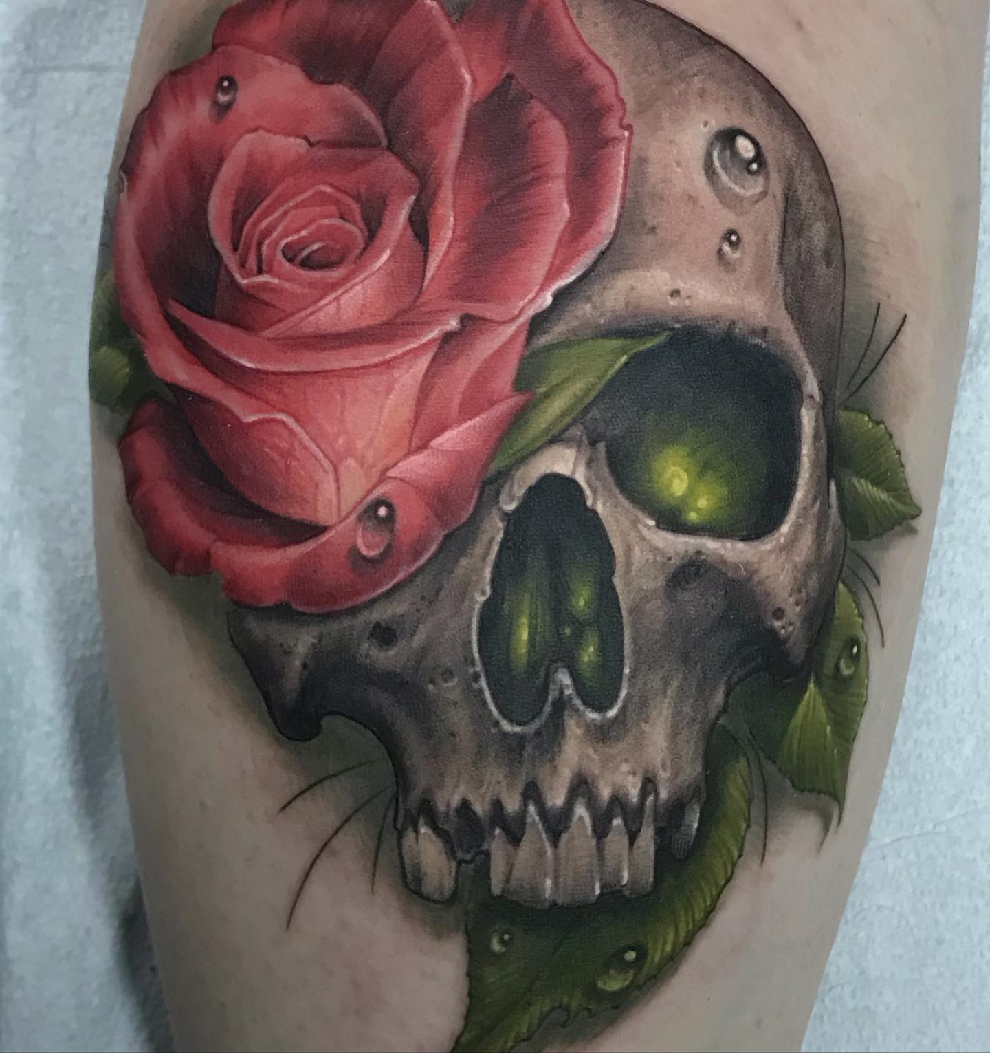 Red rose and skull realism tattoo on the forearm by Rick Rayne
