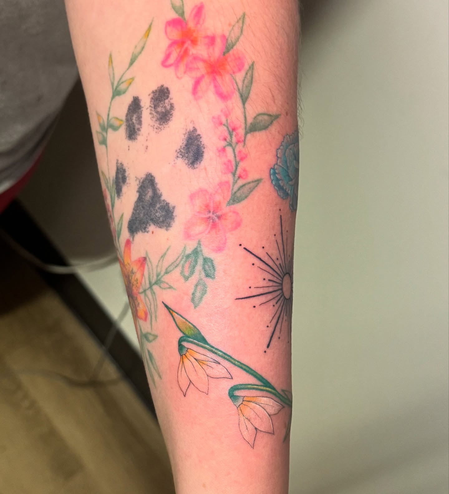 Floral arrangement watercolor tattoo on the forearm by Madison Pegram
