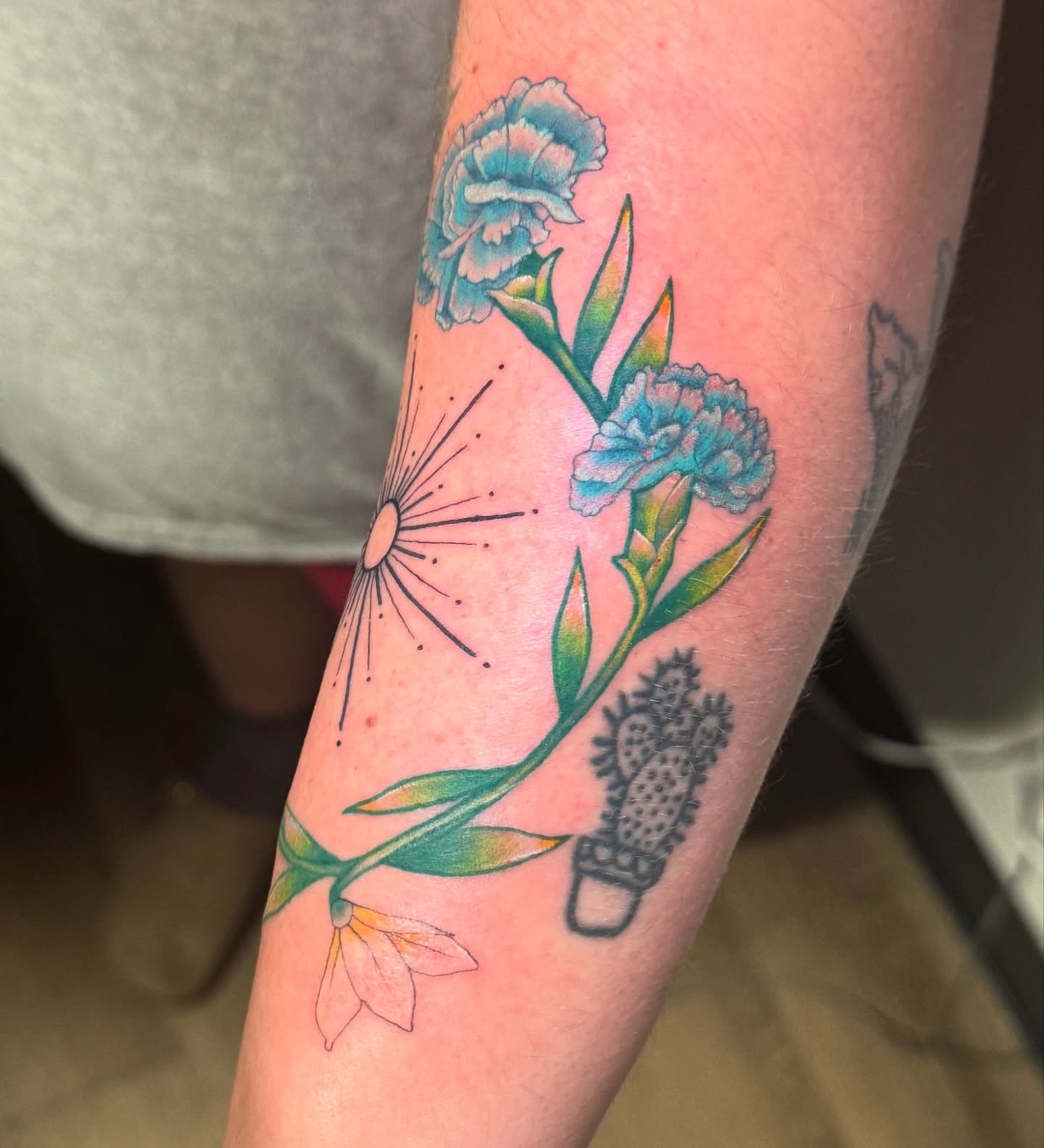 Flowers and cactus dotwork tattoo on the forearm by Madison Pegram