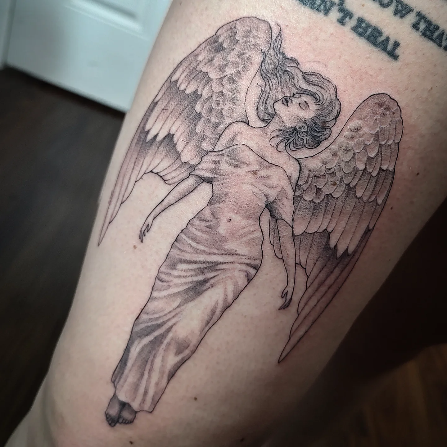 Angel realism tattoo on the thigh by Jennifer Fowler