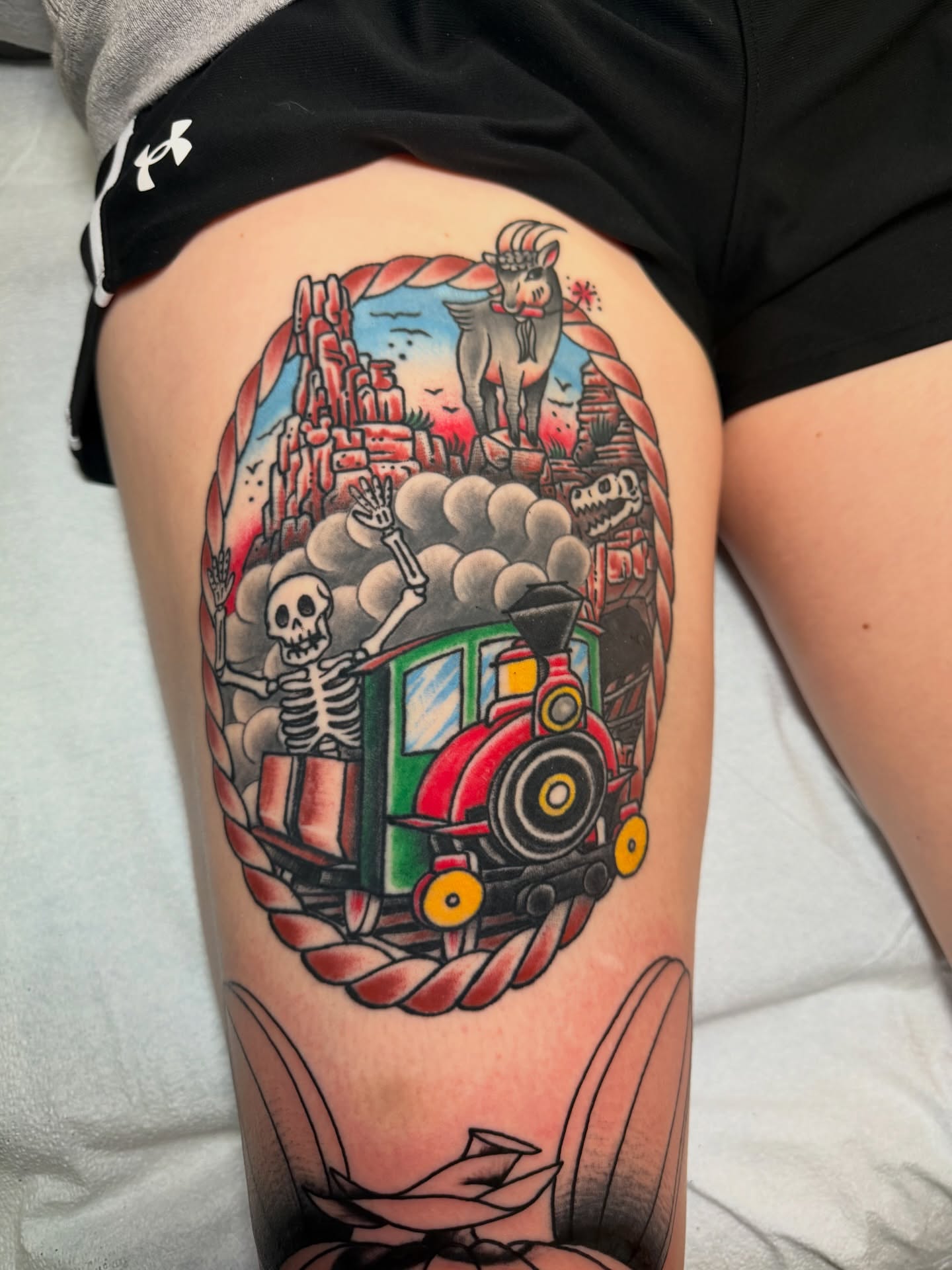Train and skeleton American traditional tattoo on the thigh by Brandon Bear