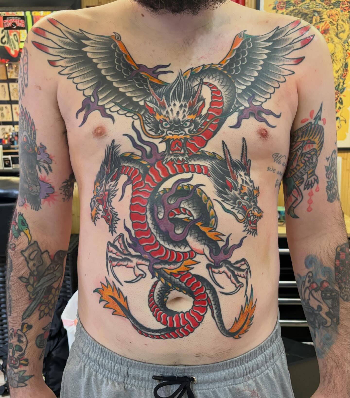 Dragon American traditional tattoo on the chest by Steve Reid
