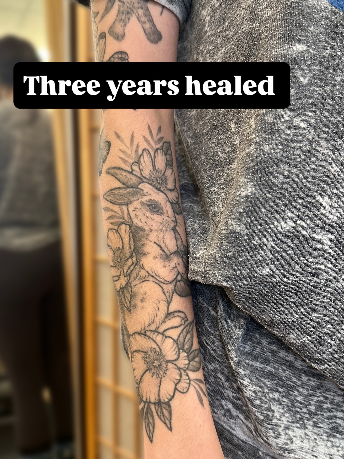 Rabbit and flowers black and grey tattoo on the forearm by Tattooing by Patty Valentine
