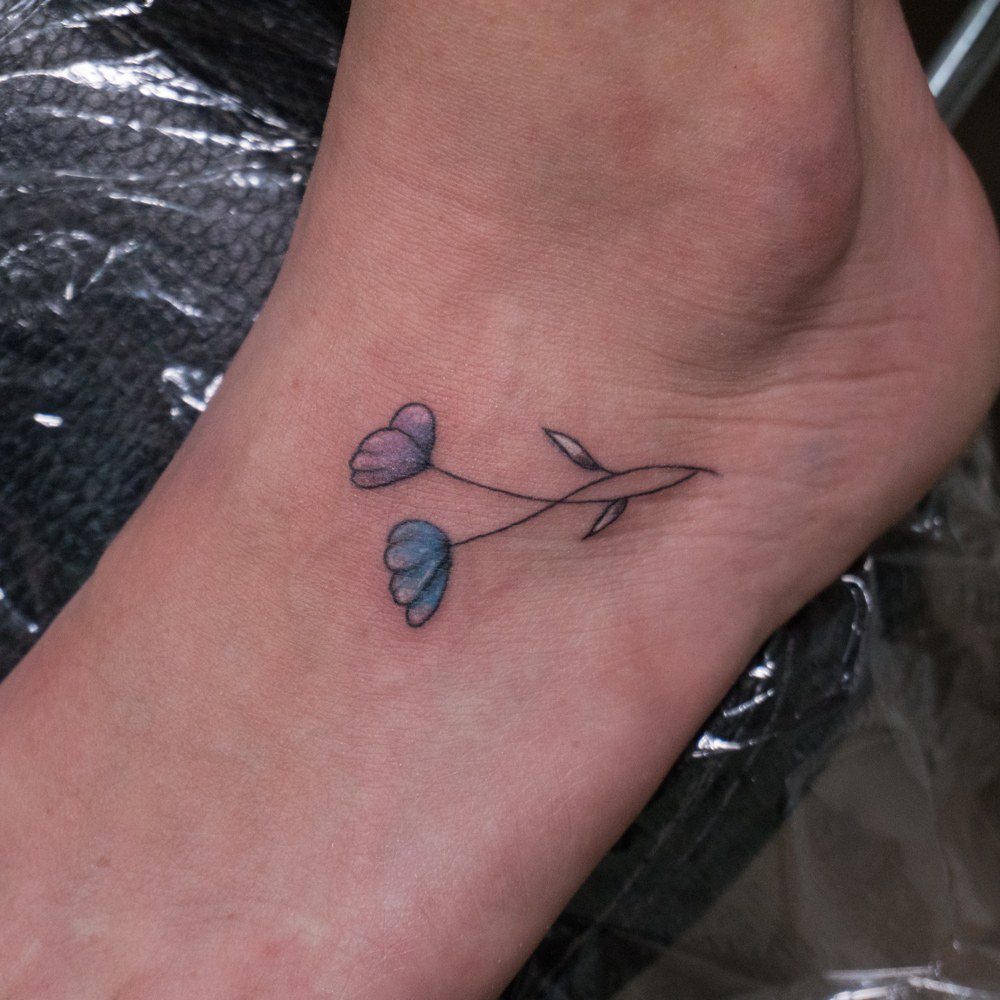 Flower fine line tattoo on the foot by Donald Voelker