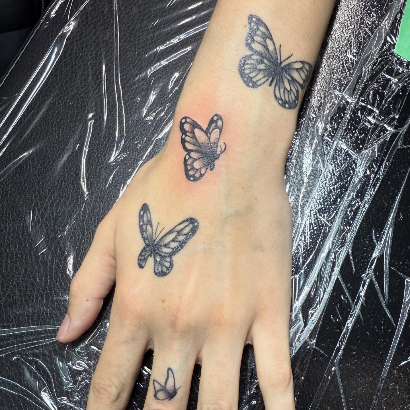Butterflies black and grey tattoo on the hand by Hunter Beyer
