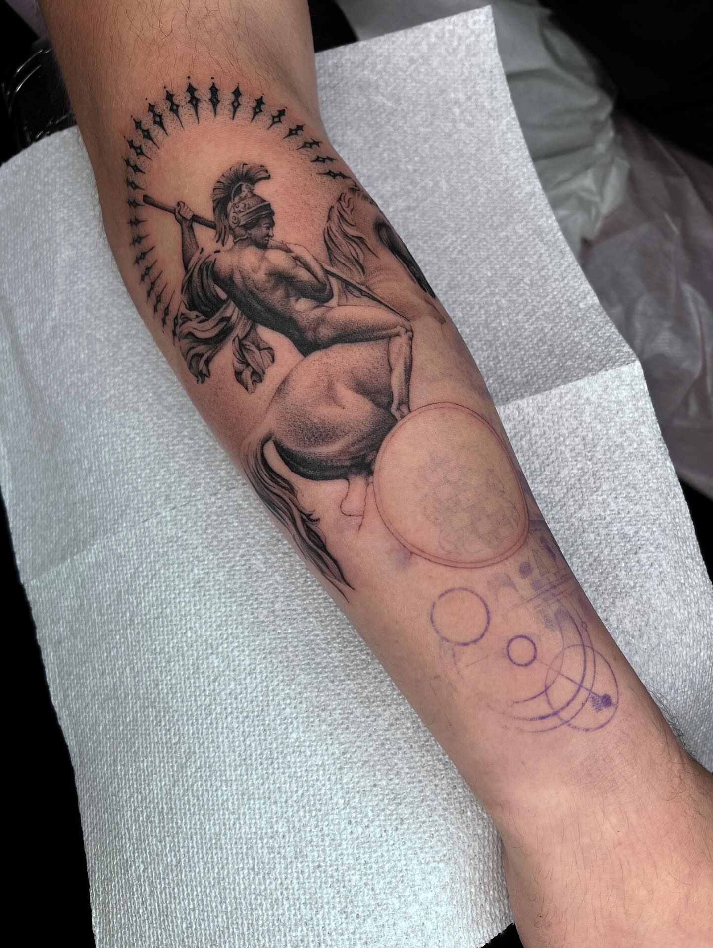 Gladiator black and grey tattoo on the forearm by Dolph.