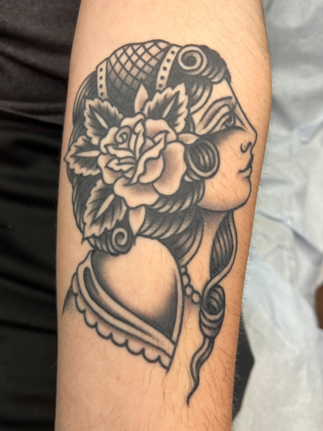 Woman with roses American traditional tattoo on the forearm by Macy Bird