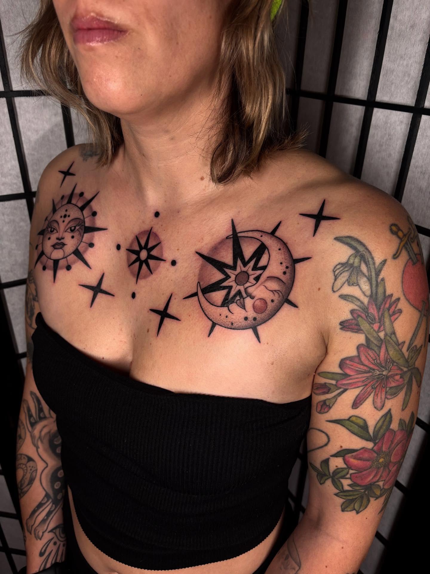 Sun, moon, stars, flowers dotwork tattoo on the chest by Victoria Bacon