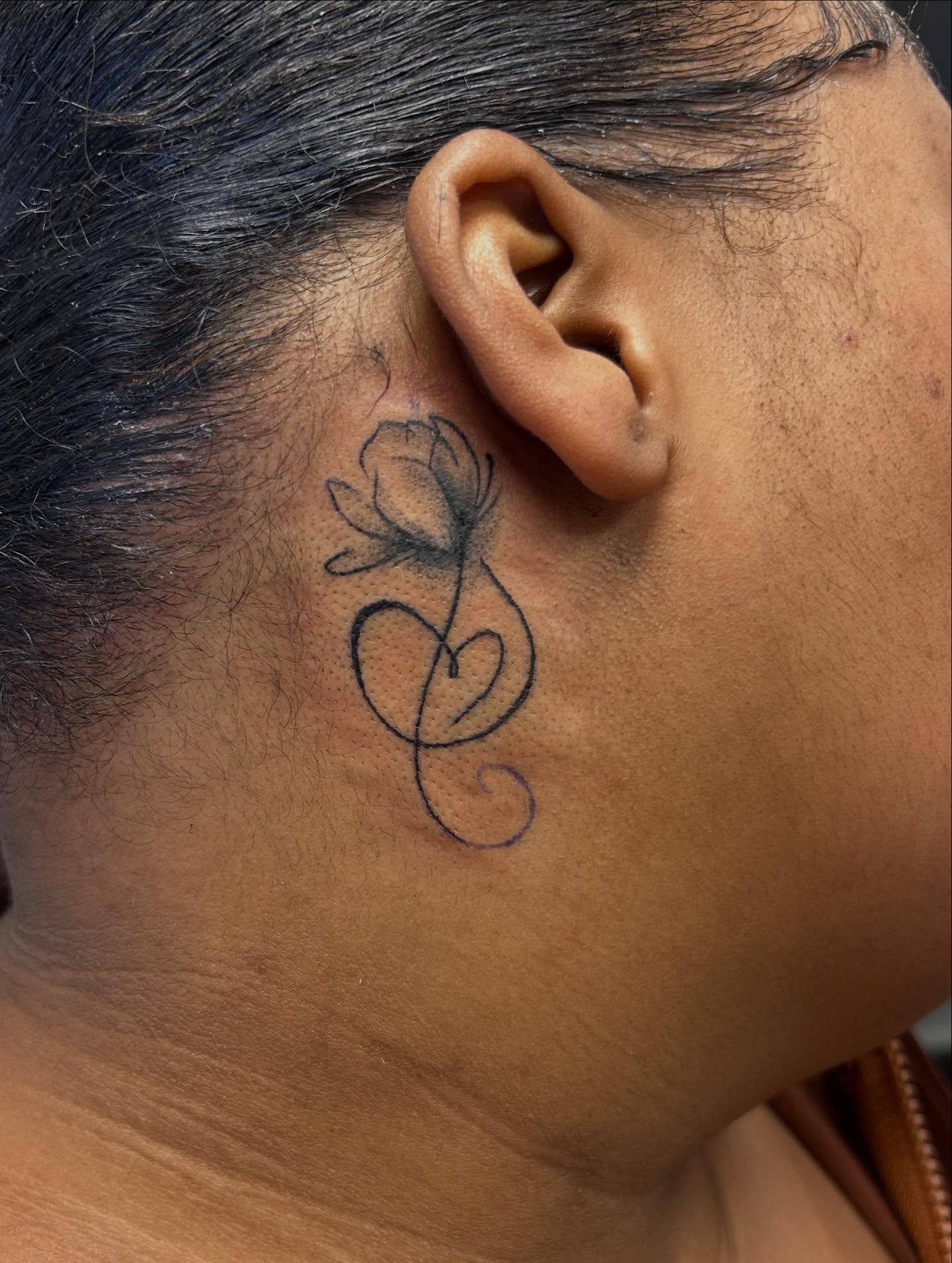 Flower and swirl fine line tattoo on the neck by Chris