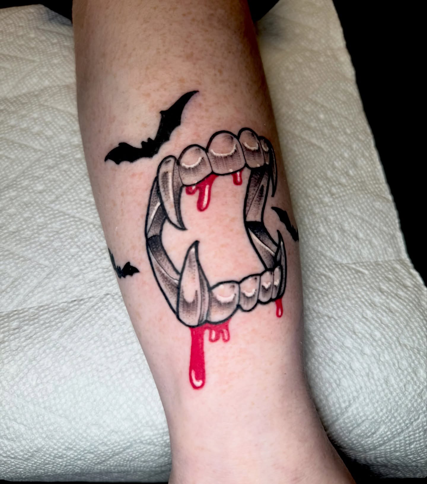 Fangs and blood black and grey tattoo on the forearm by Brett Brown