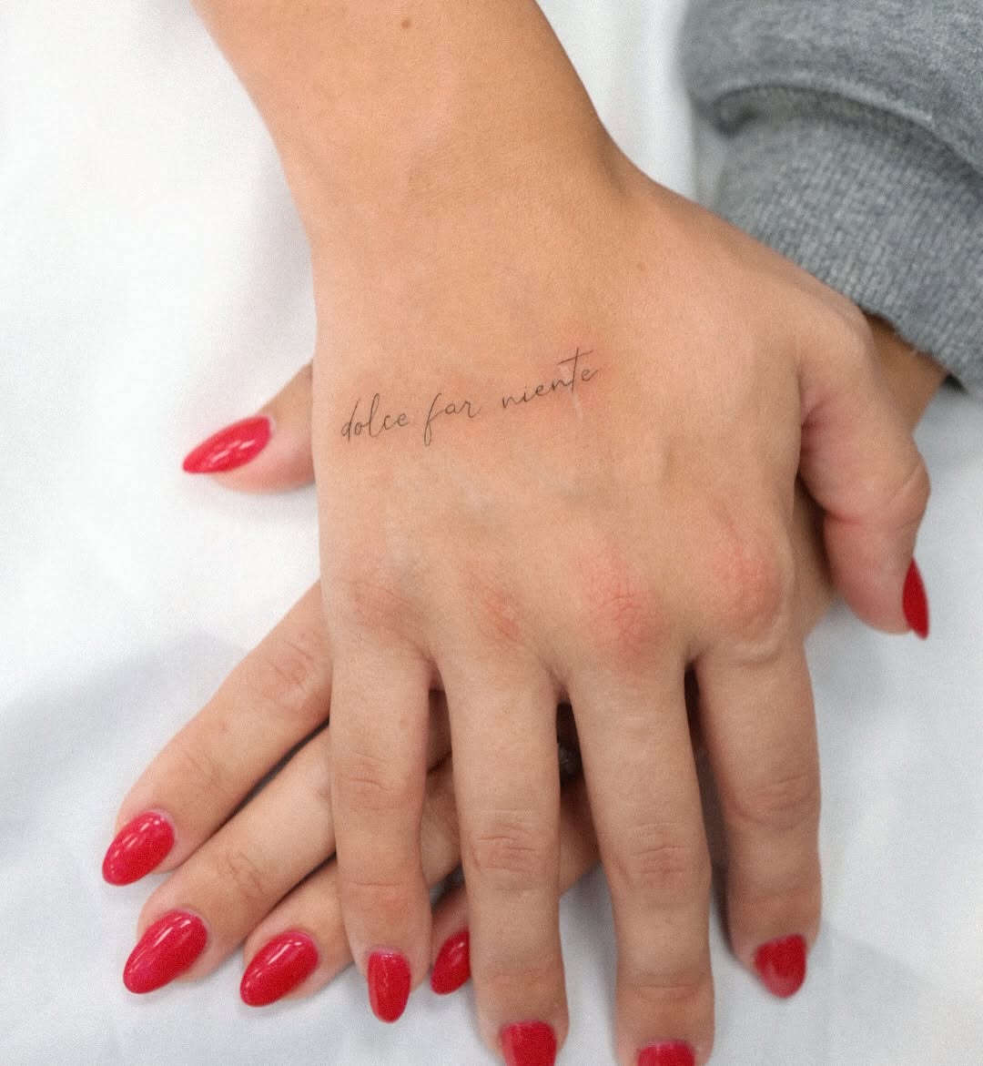 Dolce far niente script lettering tattoo on the hand by Fine Line, New York, New York