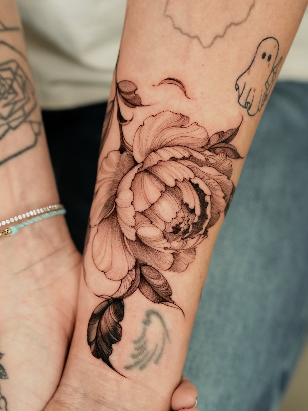 Peony flower fine line tattoo on the forearm by Valentina