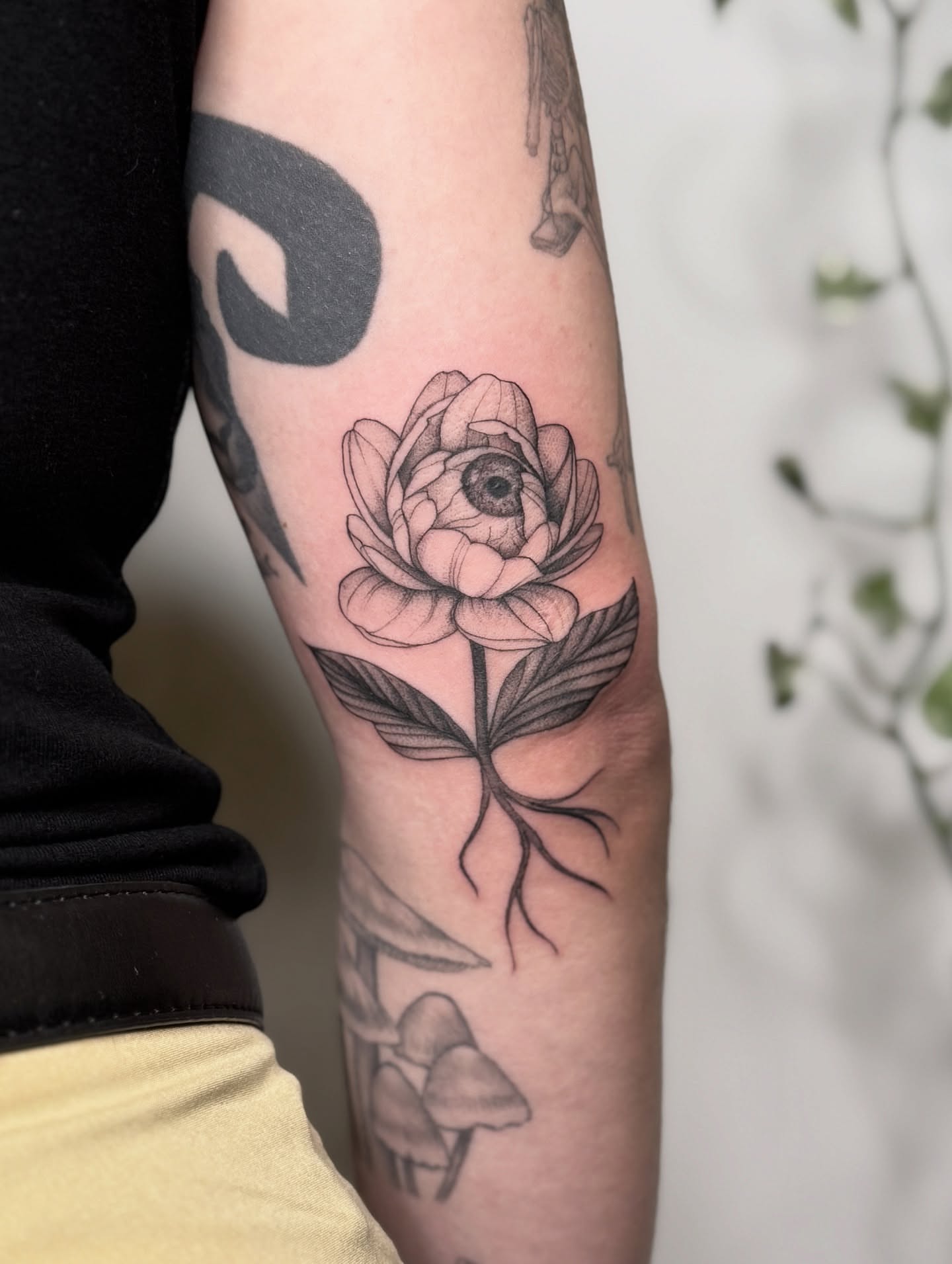 Flower with roots black and grey tattoo on the forearm by Jasmine, Lynnwood, Washington