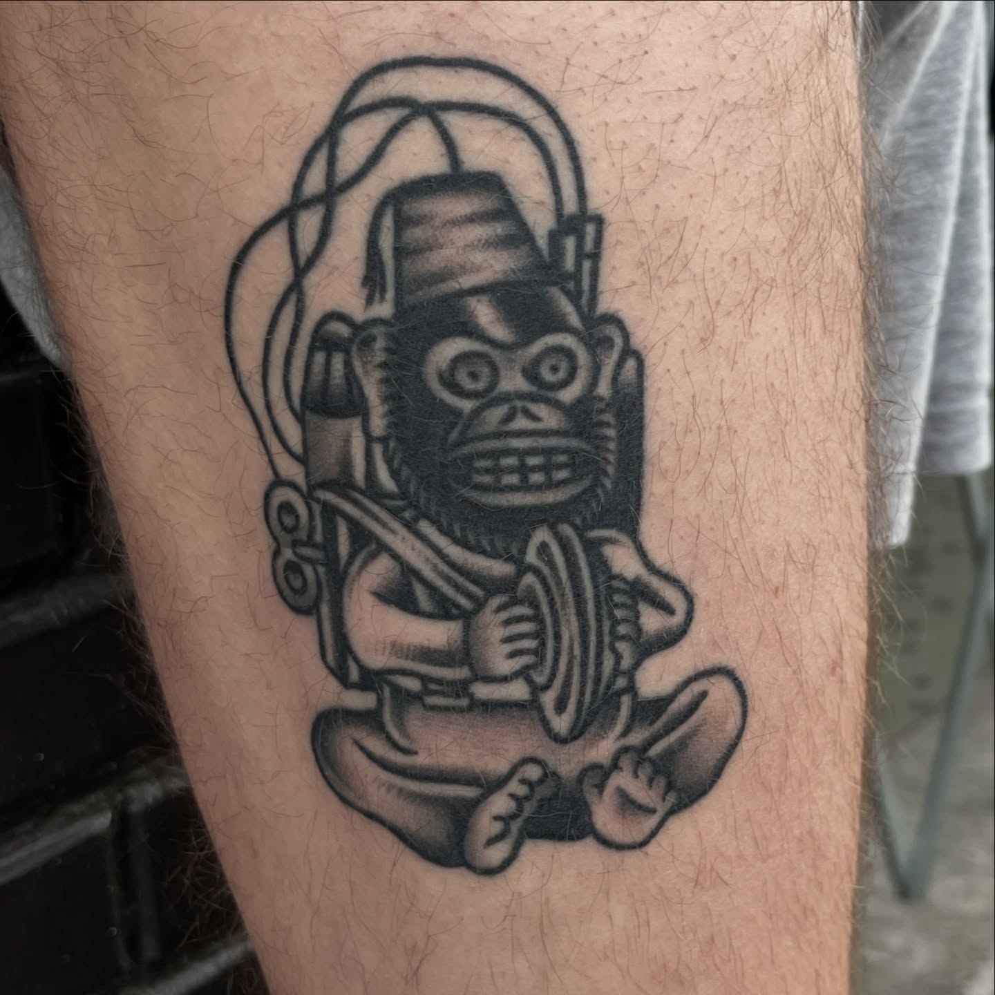 Monkey with hat black and grey tattoo on the thigh by August B., Renton, Washington