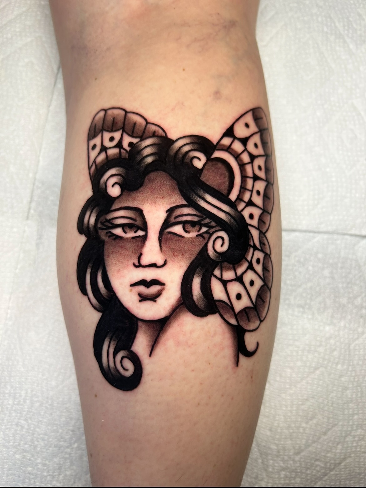 Woman's face American traditional tattoo on the forearm by Mitch Hoggard
