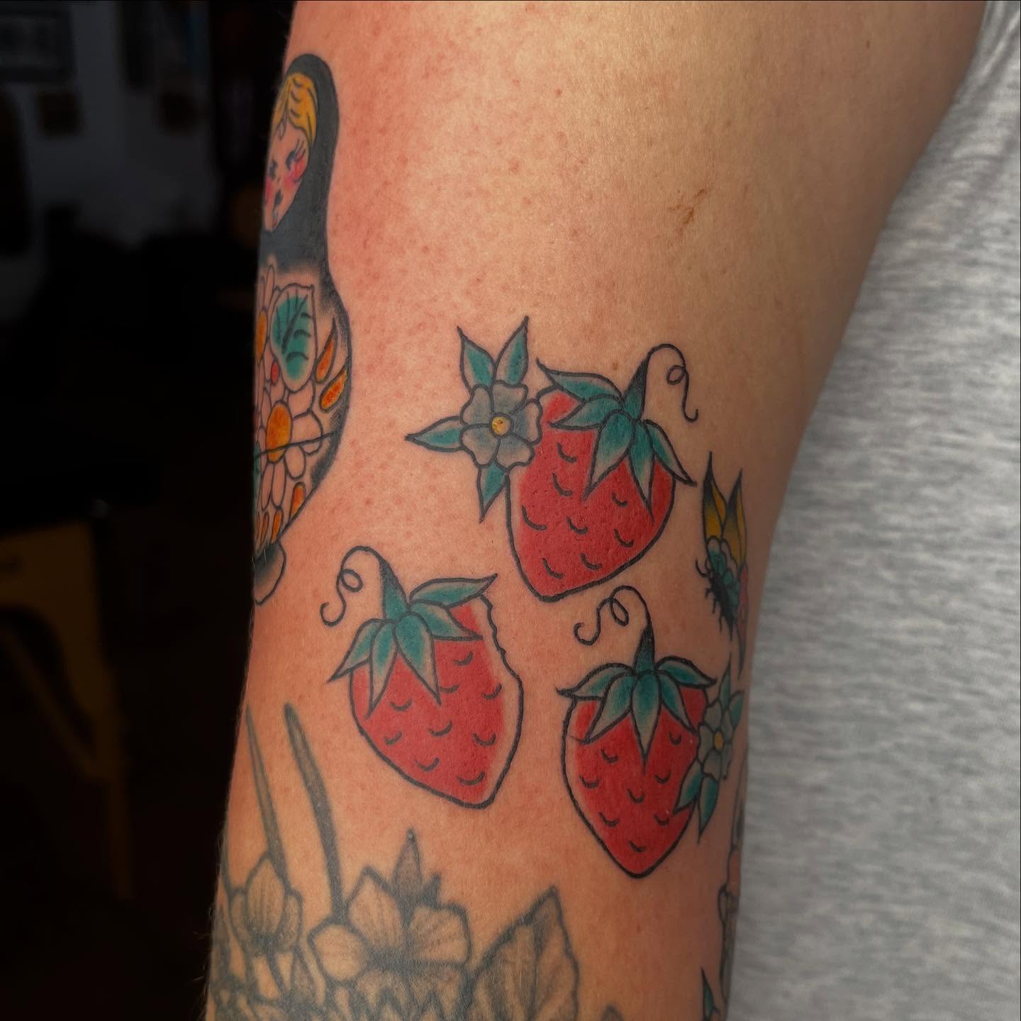 Strawberries and flowers American traditional tattoo on the forearm by Mariah Nguyen