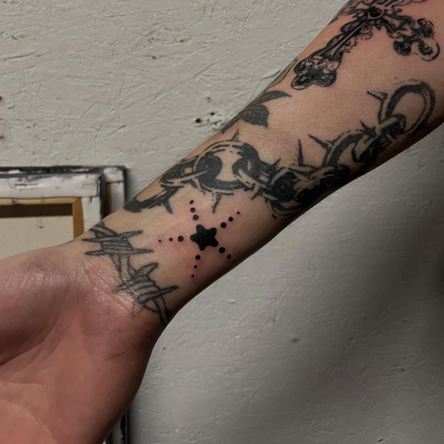 Barbed wire and star dotwork tattoo on the forearm by bisabuelita