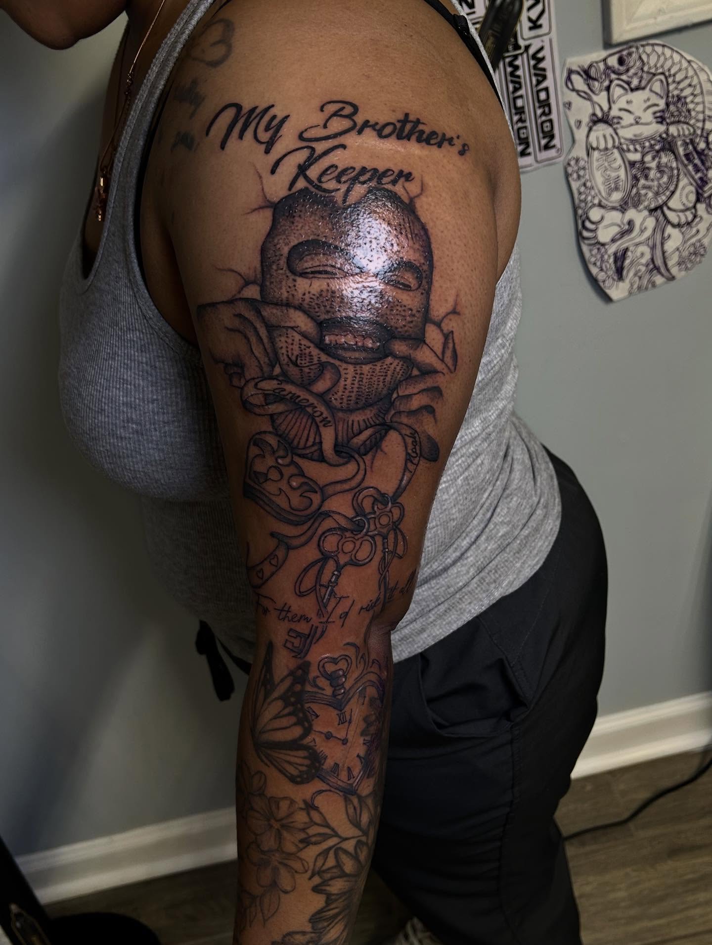 Brother's keeper black and grey tattoo on the upper arm by Stephania ATLANTA TATTOO ARTIST🎨