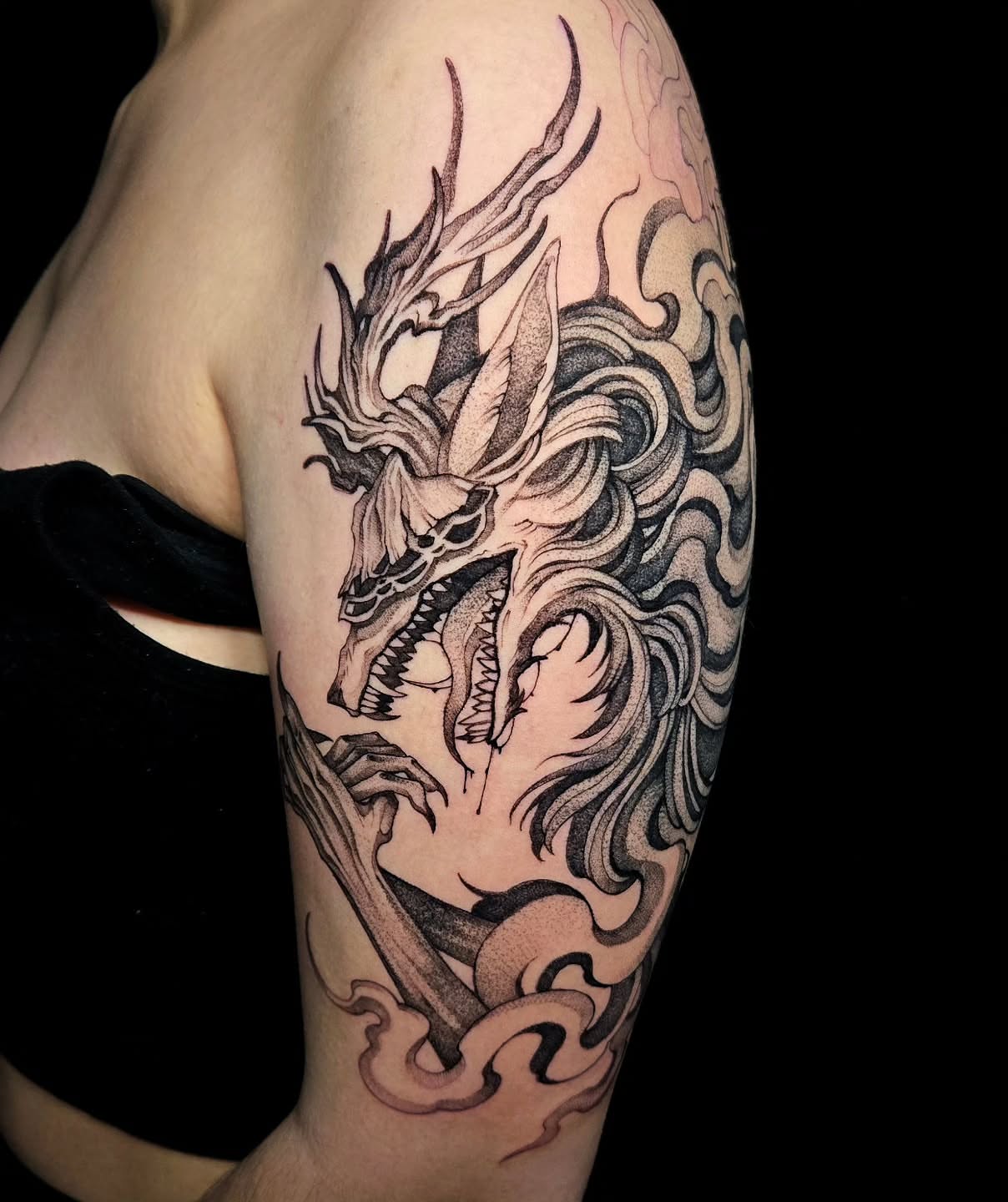 Dragon dotwork tattoo on the upper arm by Jesseca Chinchilla