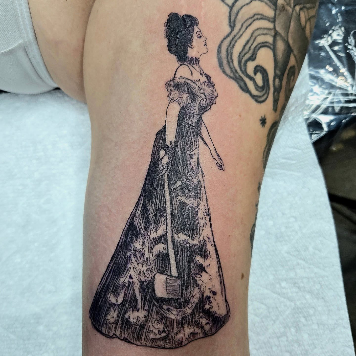 Woman in dress realism tattoo on the thigh by Amanda Hinrichs
