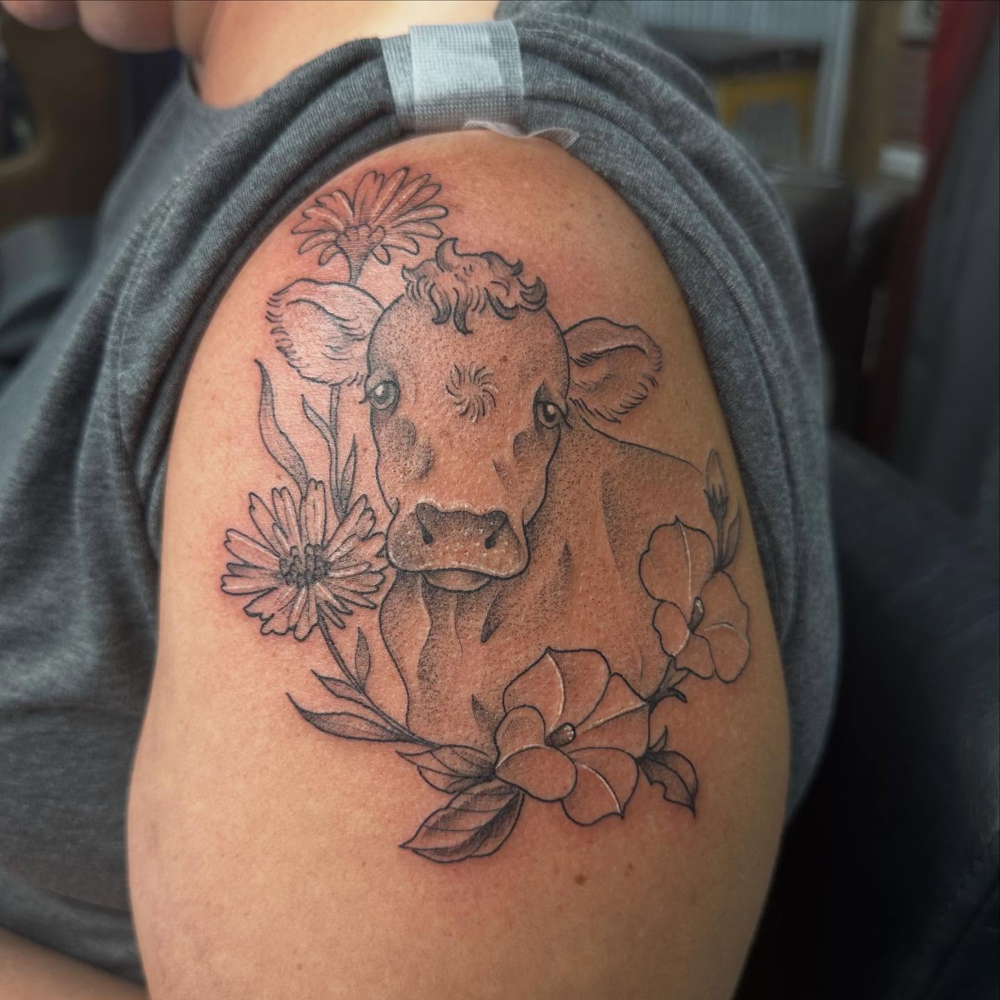 Cow and flowers realism tattoo on the shoulder by Halle Haas