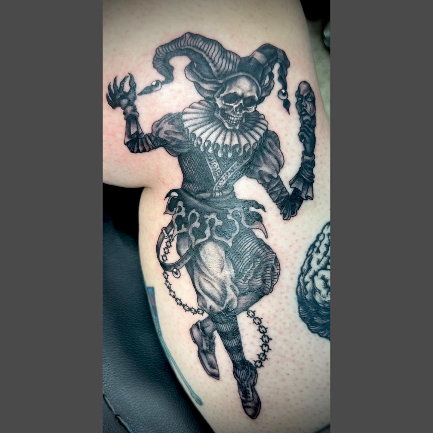 Jester black and grey tattoo on the thigh by Richard Nagy, New Orleans, Louisiana