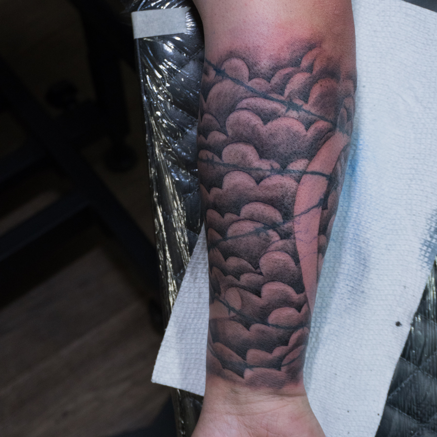 Clouds black and grey tattoo on the forearm by Donald Voelker
