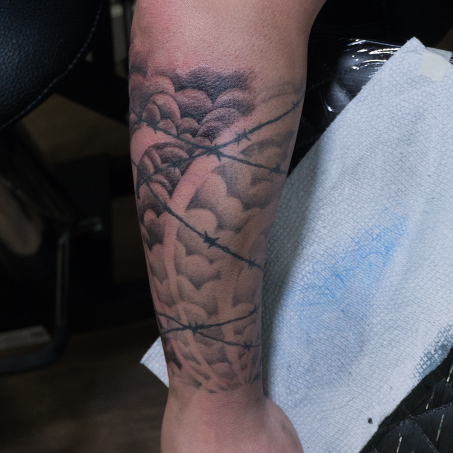 Barbed wire and hearts realism tattoo on the forearm by Donald Voelker
