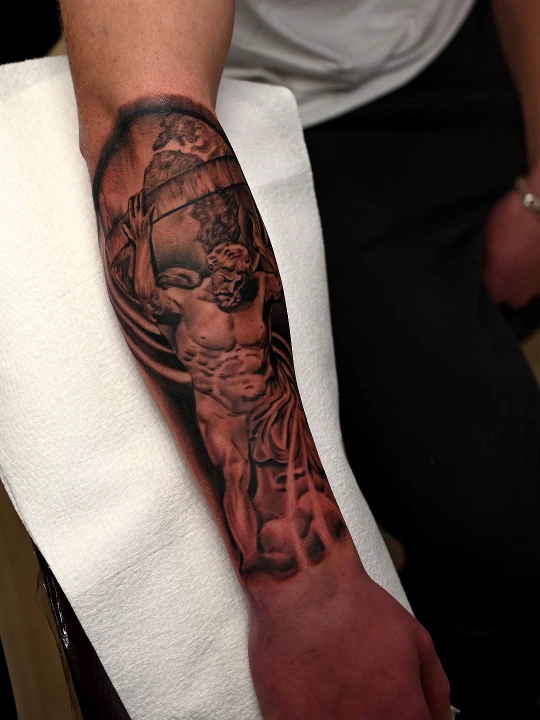 Statue of a man realism tattoo on the forearm by Michael ORegan