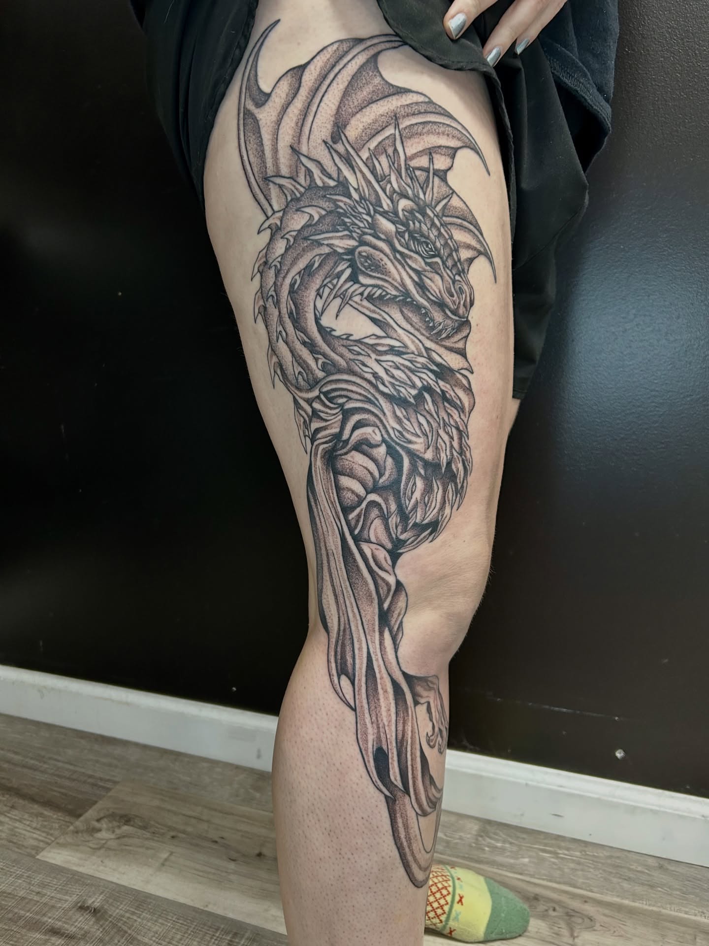 Dragon black and grey tattoo on the thigh by Taylor Heidtbrink