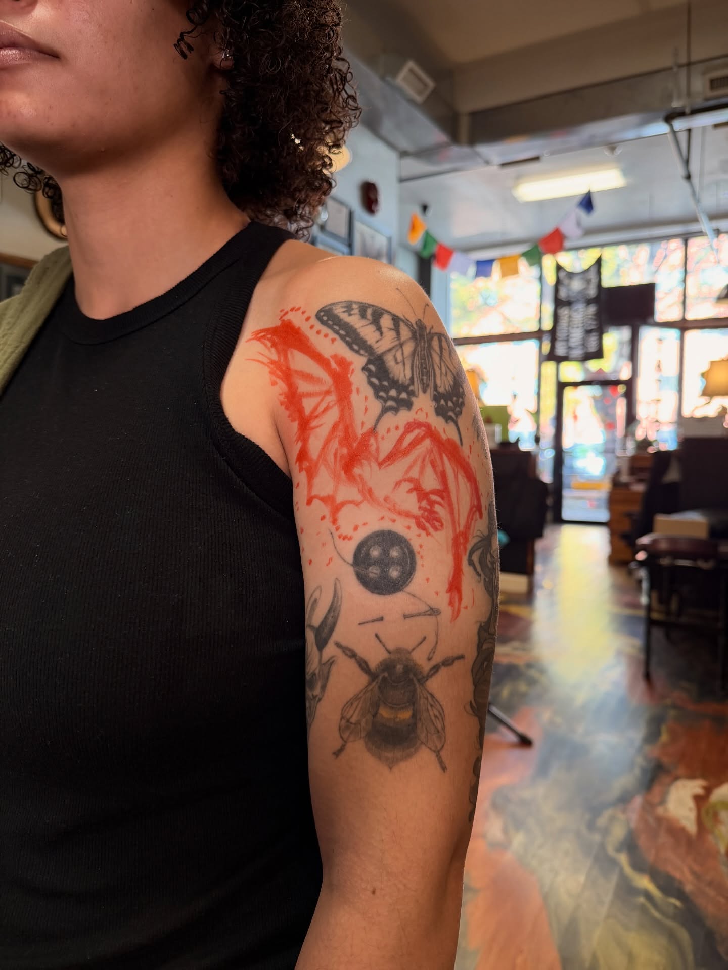 Butterfly and bee black and grey tattoo on the upper arm by Giovanna Kline