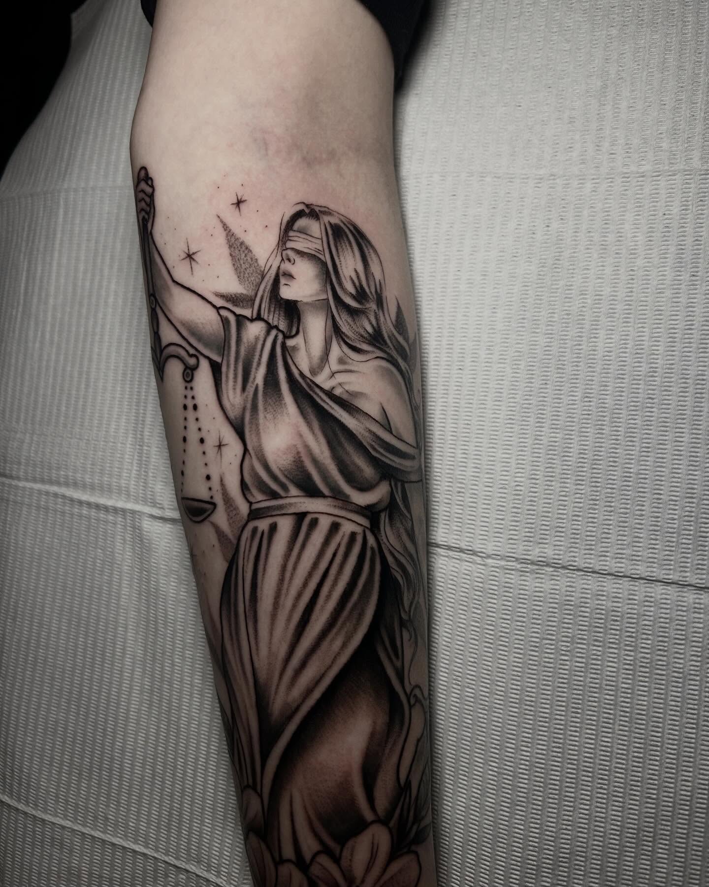 Statue of justice realism tattoo on the forearm by Heaven Arianna