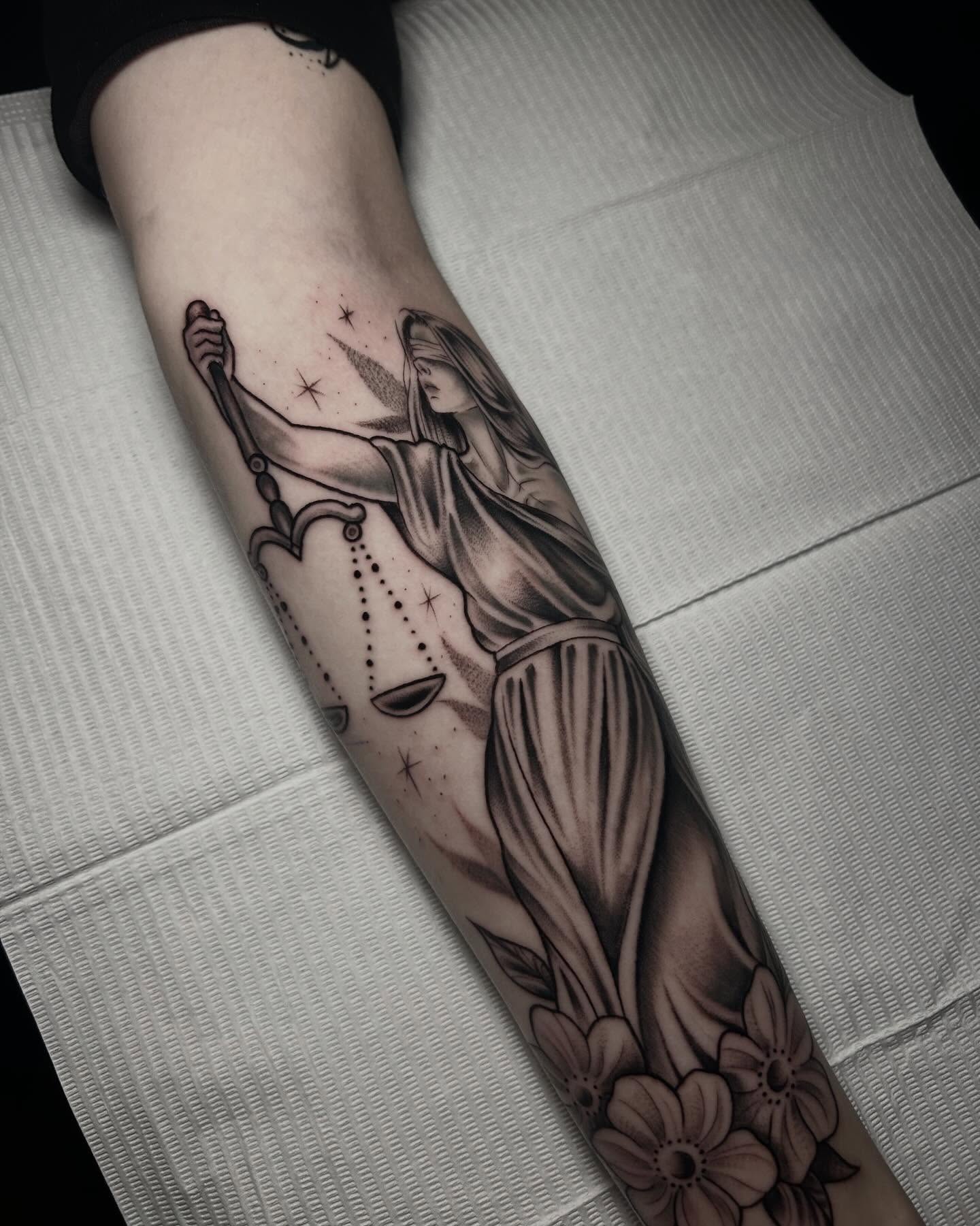 Justice statue black and grey tattoo on the forearm by Heaven Arianna