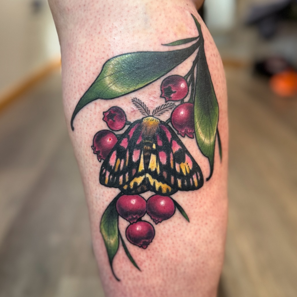 Butterfly and berries realism tattoo on the forearm by Erin Bratzler